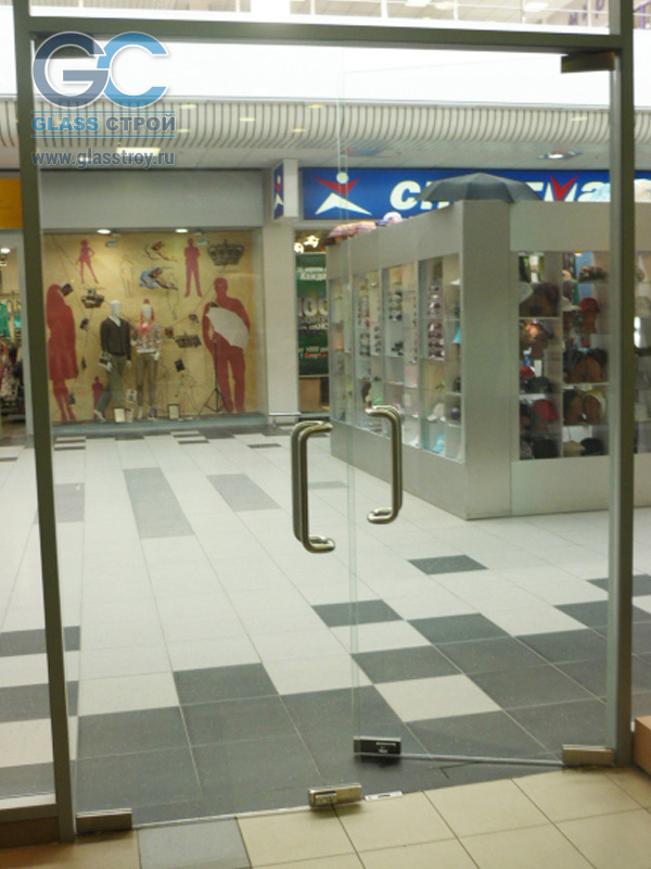 Приоткрытые стеклянные двери в торговом комплексе внутри помещения