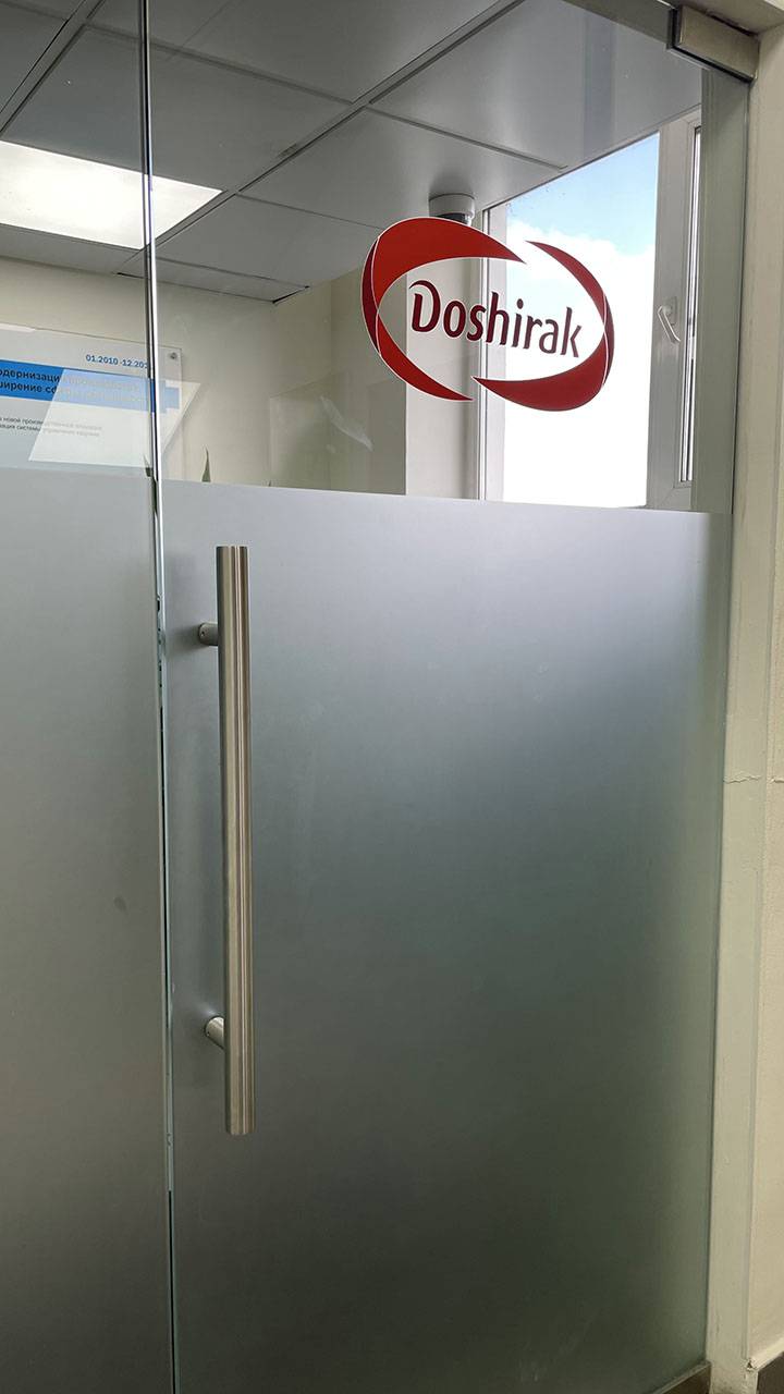 Стеклянная дверь в офисе с логотипом компании