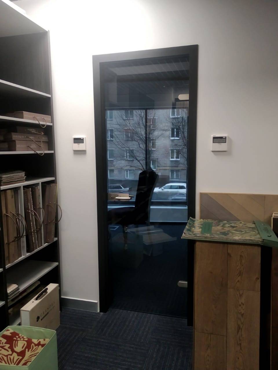 Тонированная цельностеклянная дверь в офисе