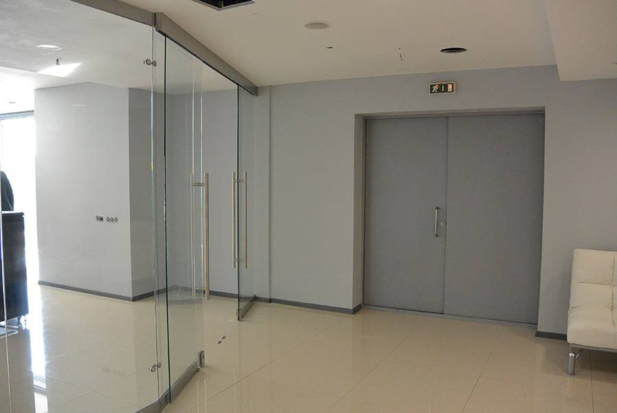 Раздвижные двери и стеклянные перегородки зонирующие пространство в офисе