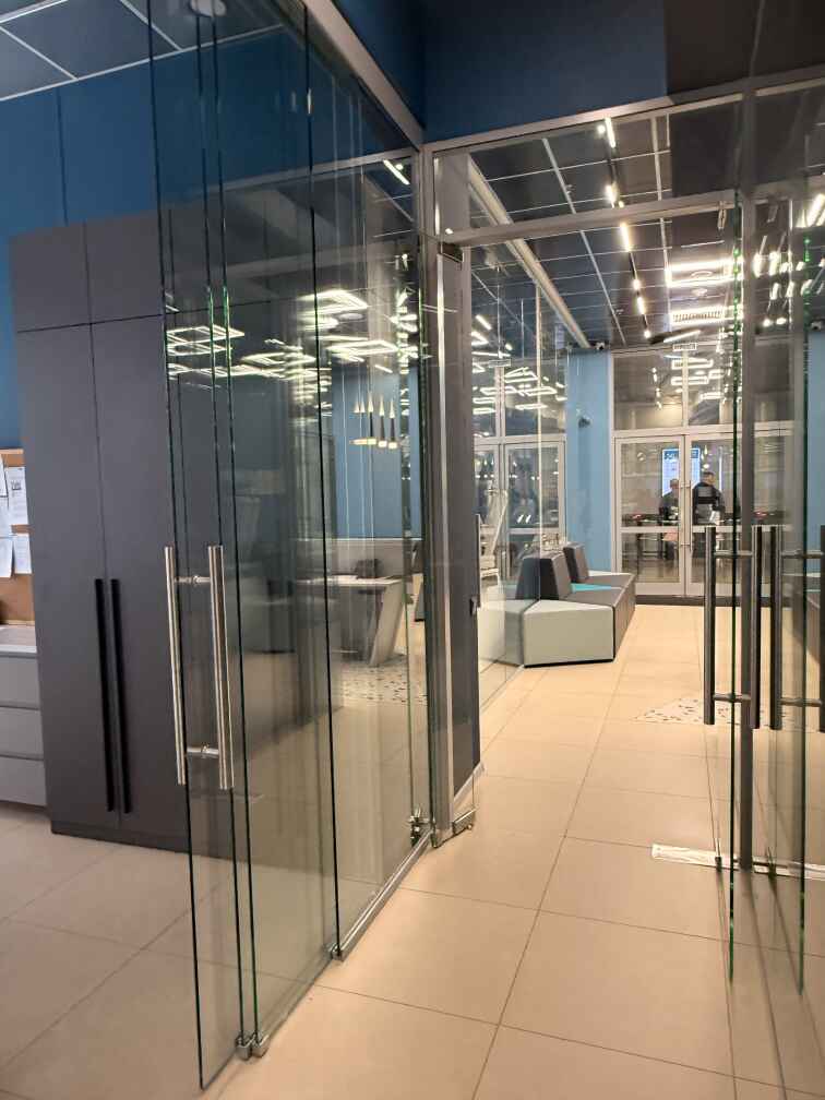 Цельностеклянные перегородки и раздвижные двери в офисе